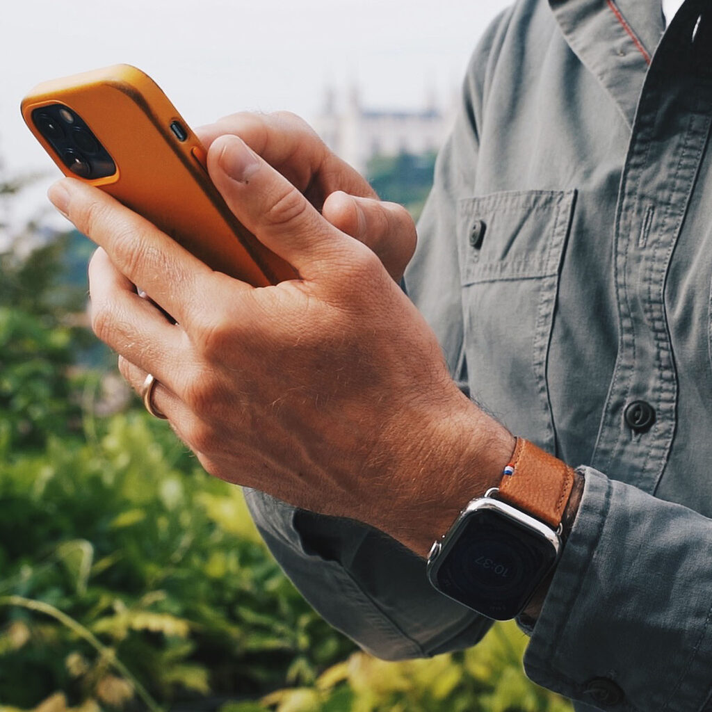 Homme avec iPhone et Apple Watch bracelet poisson Eternel